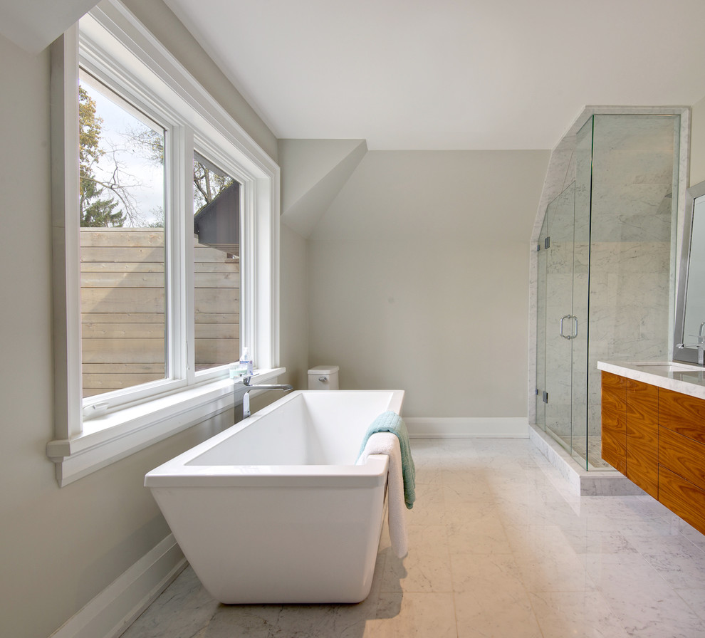 Mid-sized contemporary master bathroom in Toronto with an integrated sink, flat-panel cabinets, medium wood cabinets, engineered quartz benchtops, a freestanding tub, an open shower, a one-piece toilet, gray tile, porcelain tile, grey walls and porcelain floors.