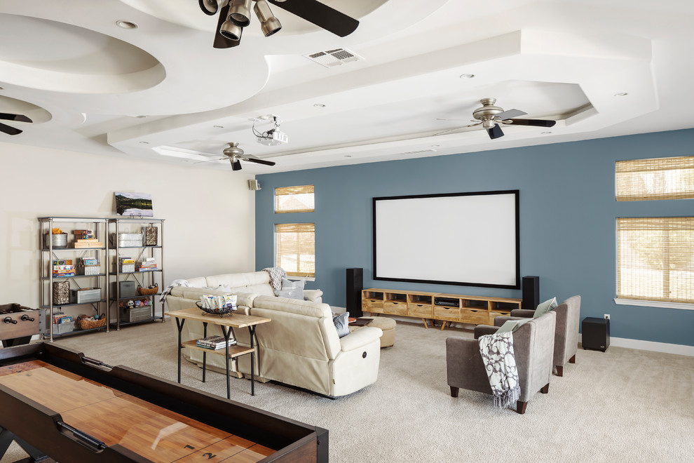 This is an example of a large transitional open concept home theatre in Phoenix with a wall-mounted tv, beige floor, blue walls and carpet.