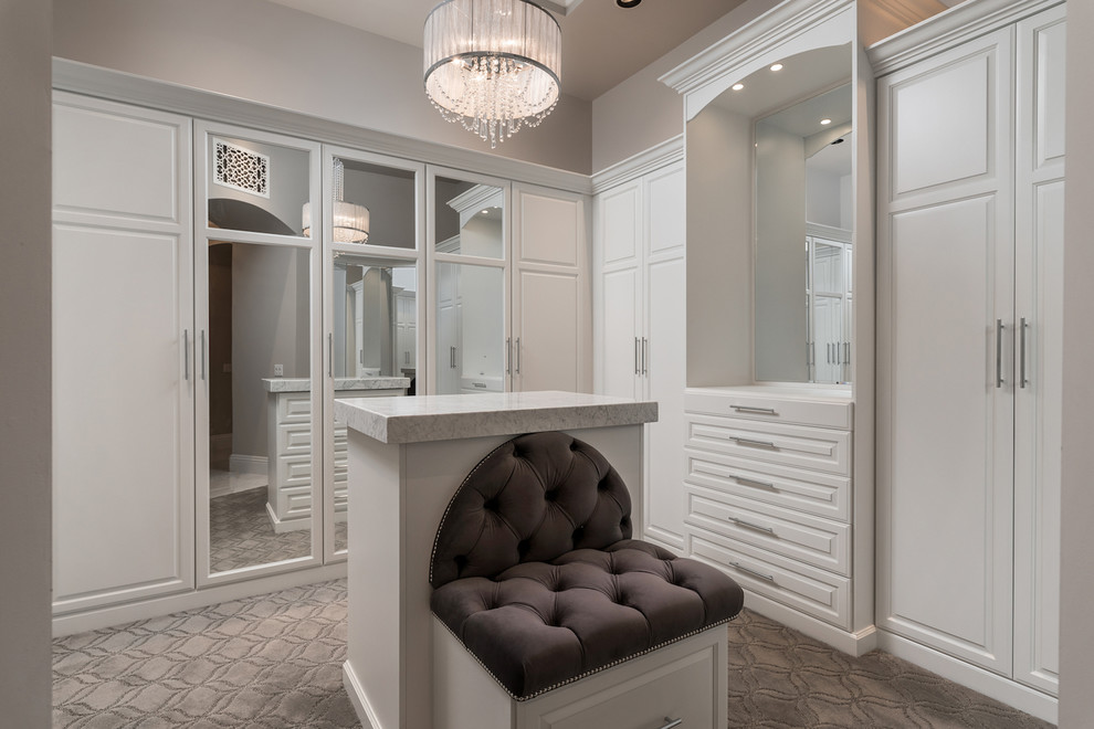 Inspiration for an expansive mediterranean gender-neutral dressing room in Phoenix with recessed-panel cabinets, white cabinets, carpet and grey floor.