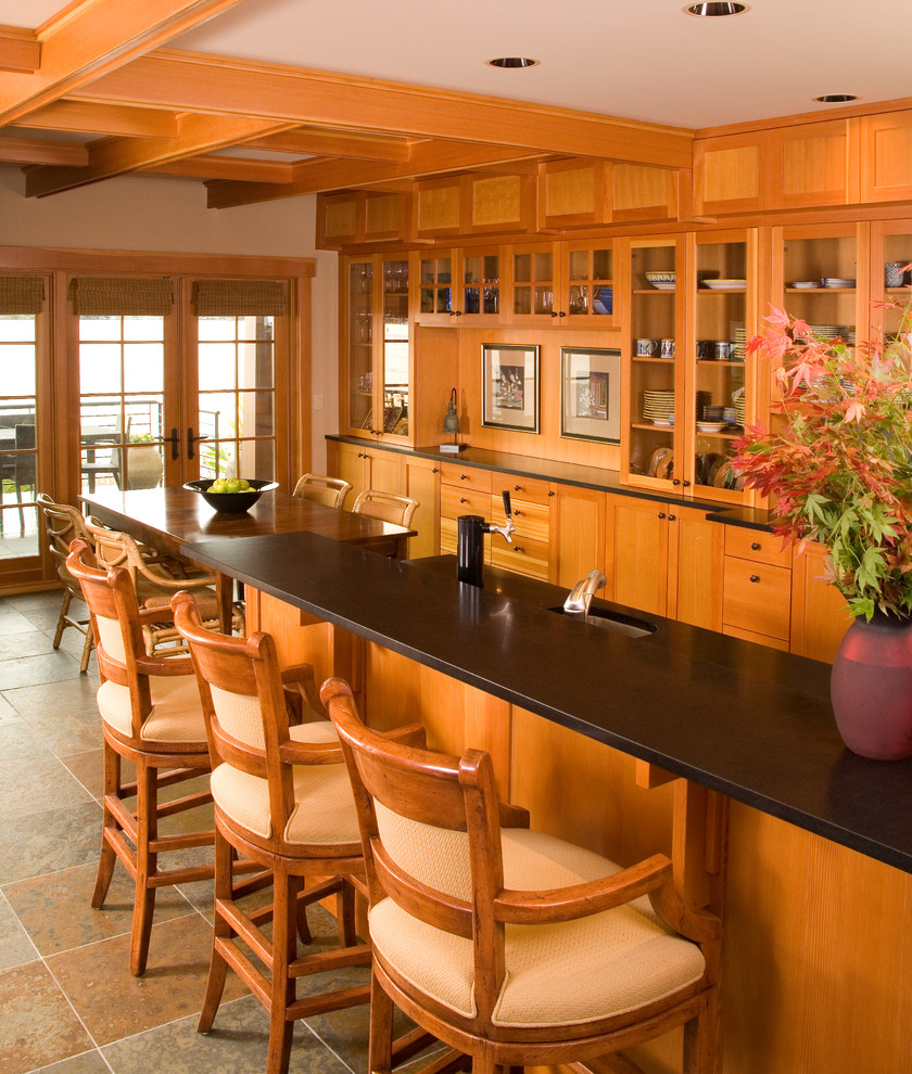 Photo of an arts and crafts galley eat-in kitchen in Seattle with glass-front cabinets, medium wood cabinets, granite benchtops and an undermount sink.