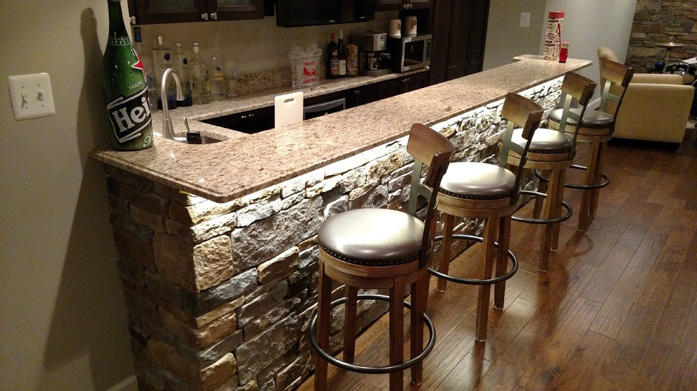This is an example of a large classic u-shaped breakfast bar in DC Metro with a submerged sink, dark wood cabinets, granite worktops and dark hardwood flooring.