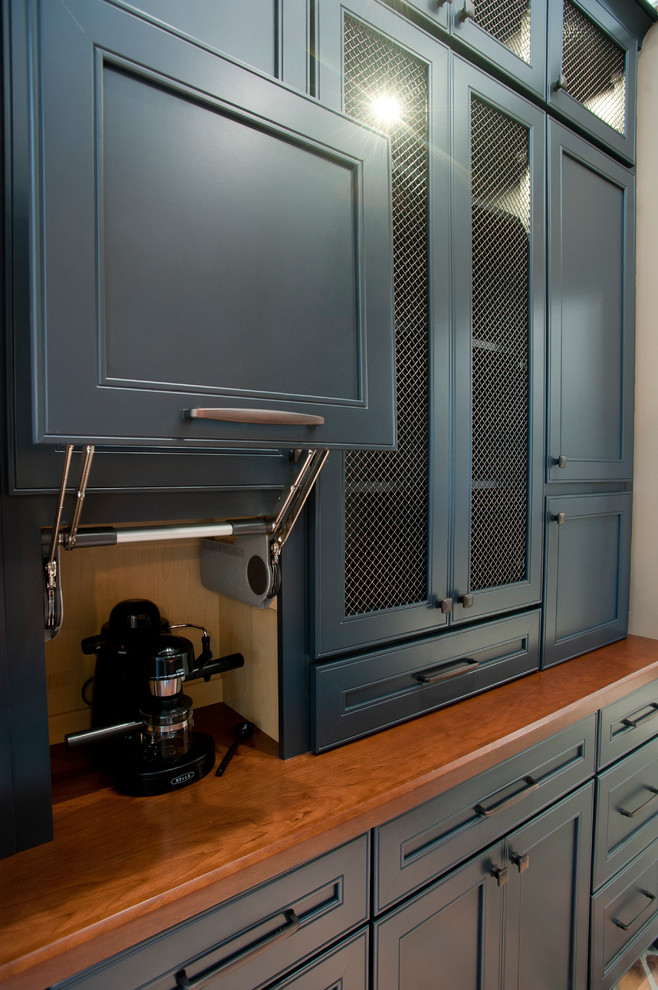 Photo of a contemporary galley wet bar in Atlanta with no sink, recessed-panel cabinets, blue cabinets, wood benchtops, beige splashback and mosaic tile splashback.