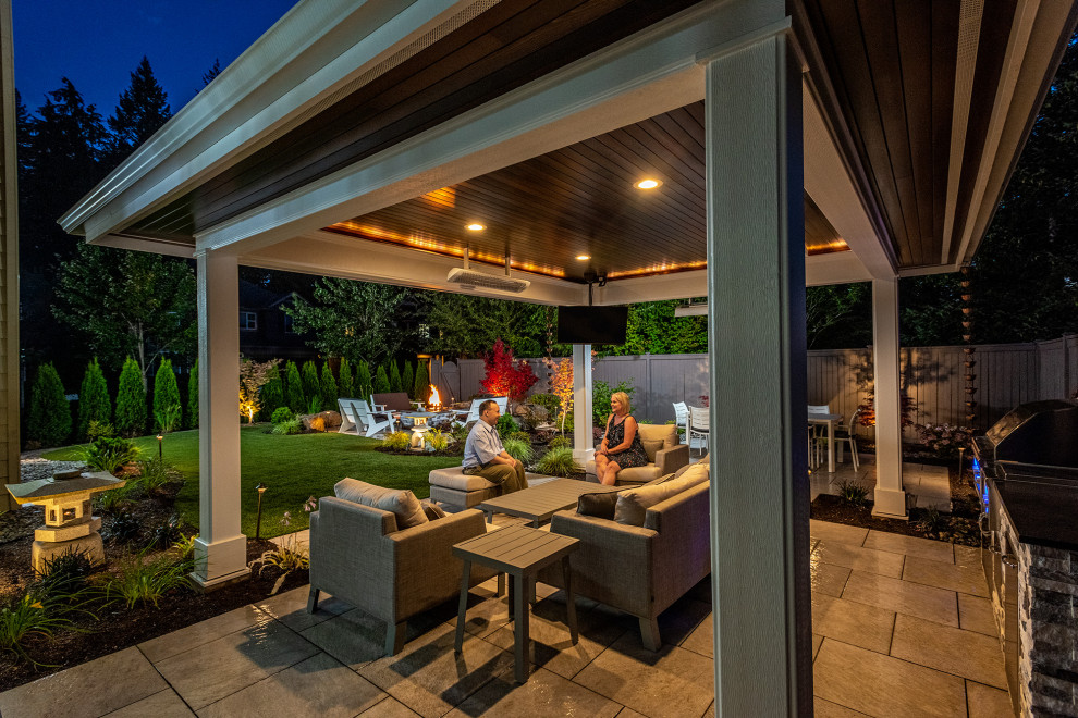This is an example of a mid-sized asian backyard patio in Seattle with an outdoor kitchen, natural stone pavers and a gazebo/cabana.