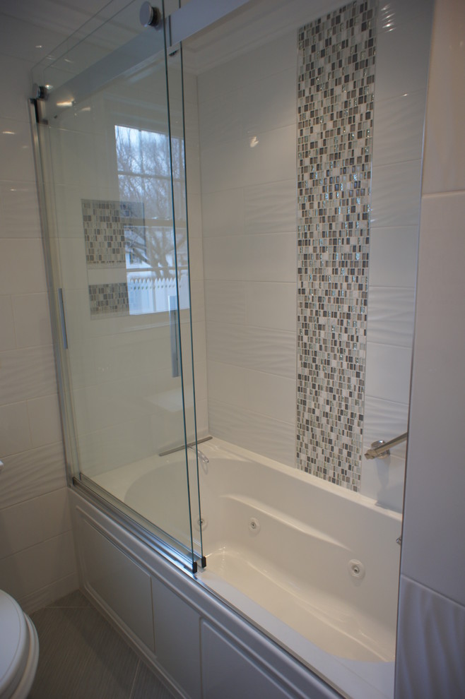 Photo of a small transitional bathroom in New York with grey cabinets, a drop-in tub, white tile, ceramic tile, ceramic floors, a vessel sink and engineered quartz benchtops.