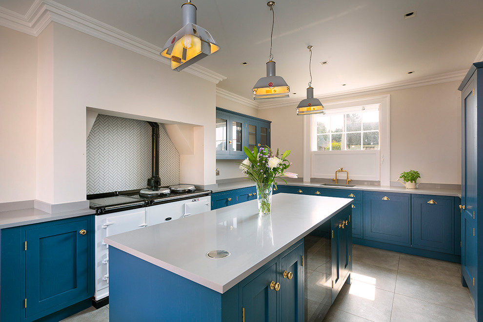 Photo of a large transitional u-shaped kitchen in Other with an undermount sink, blue cabinets, white splashback, white appliances, with island, grey floor, white benchtop and shaker cabinets.