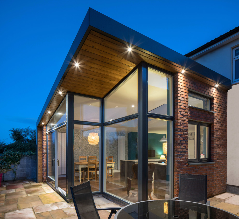 This is an example of a mid-sized contemporary brick exterior in Dublin with a shed roof.