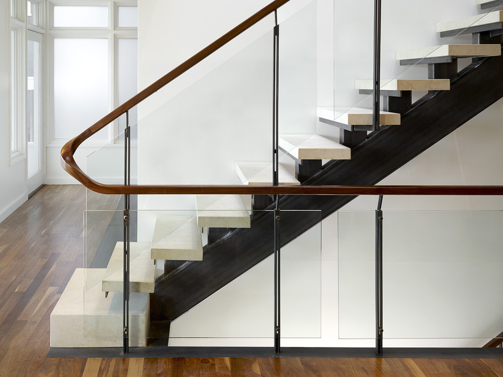 Industrial limestone straight staircase in San Francisco with glass railing and open risers.
