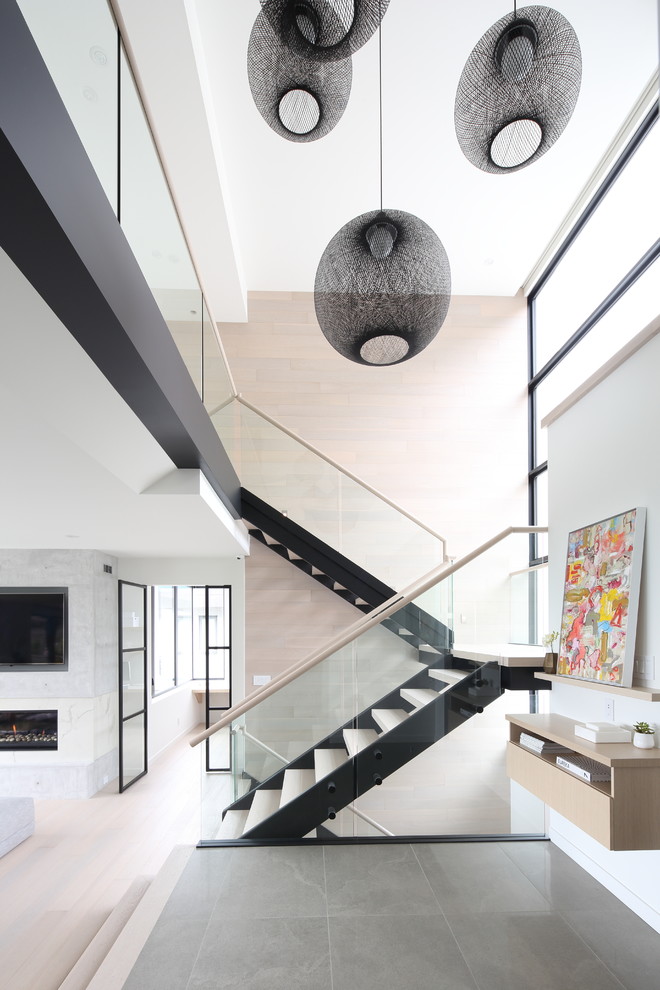 Inspiration for a large scandinavian wood u-shaped staircase in Vancouver with open risers and glass railing.