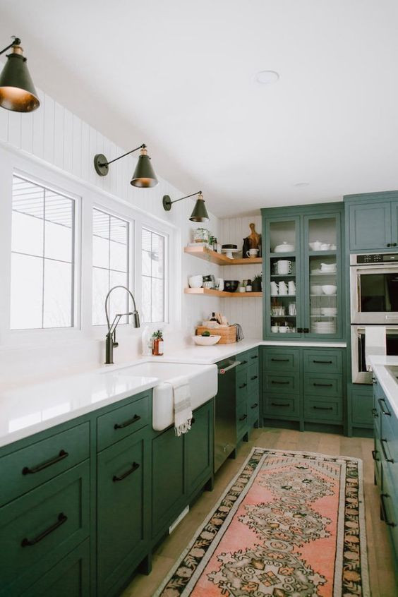 Inspiration for a large eclectic l-shaped kitchen in Columbus with a farmhouse sink, recessed-panel cabinets, green cabinets, quartz benchtops, white splashback, stainless steel appliances, light hardwood floors, with island, brown floor and white benchtop.