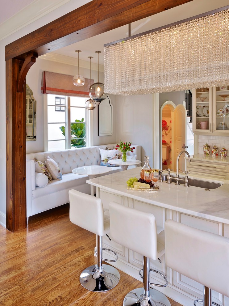 Design ideas for a small eclectic galley eat-in kitchen in Orlando with white splashback, with island, a single-bowl sink, raised-panel cabinets, distressed cabinets, marble benchtops, porcelain splashback, stainless steel appliances and medium hardwood floors.