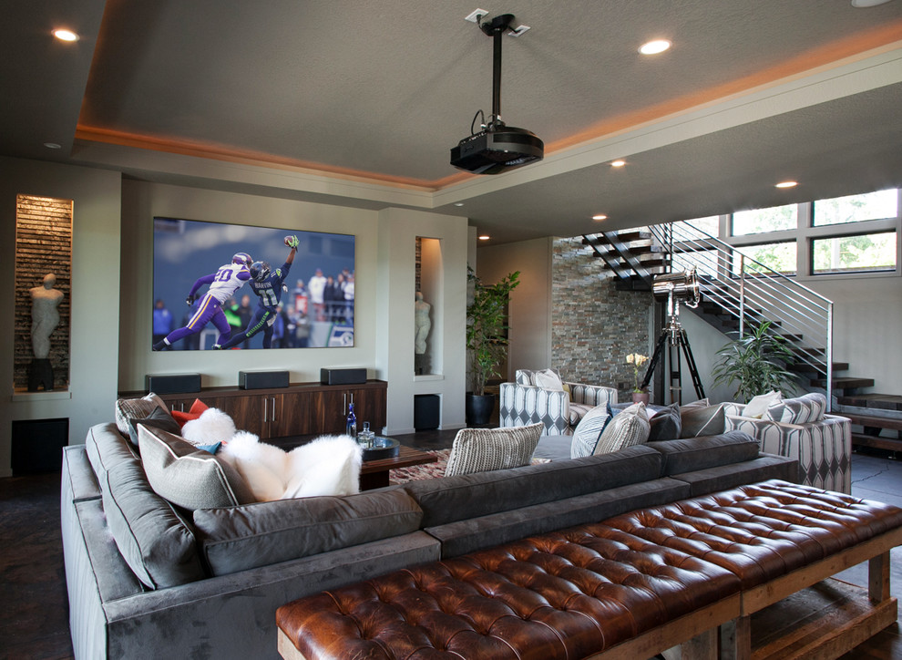 Photo of a large contemporary open concept home theatre in Portland with a projector screen, grey walls and black floor.