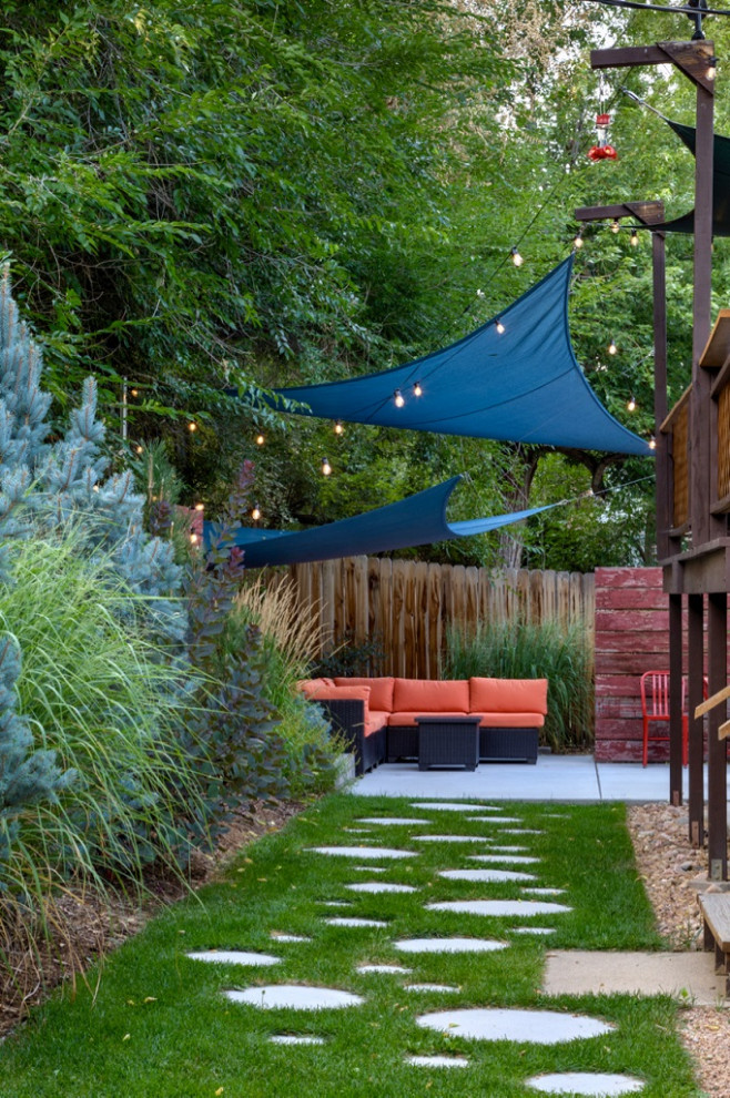 Design ideas for a small modern partial sun backyard landscaping in Denver with a fire pit.