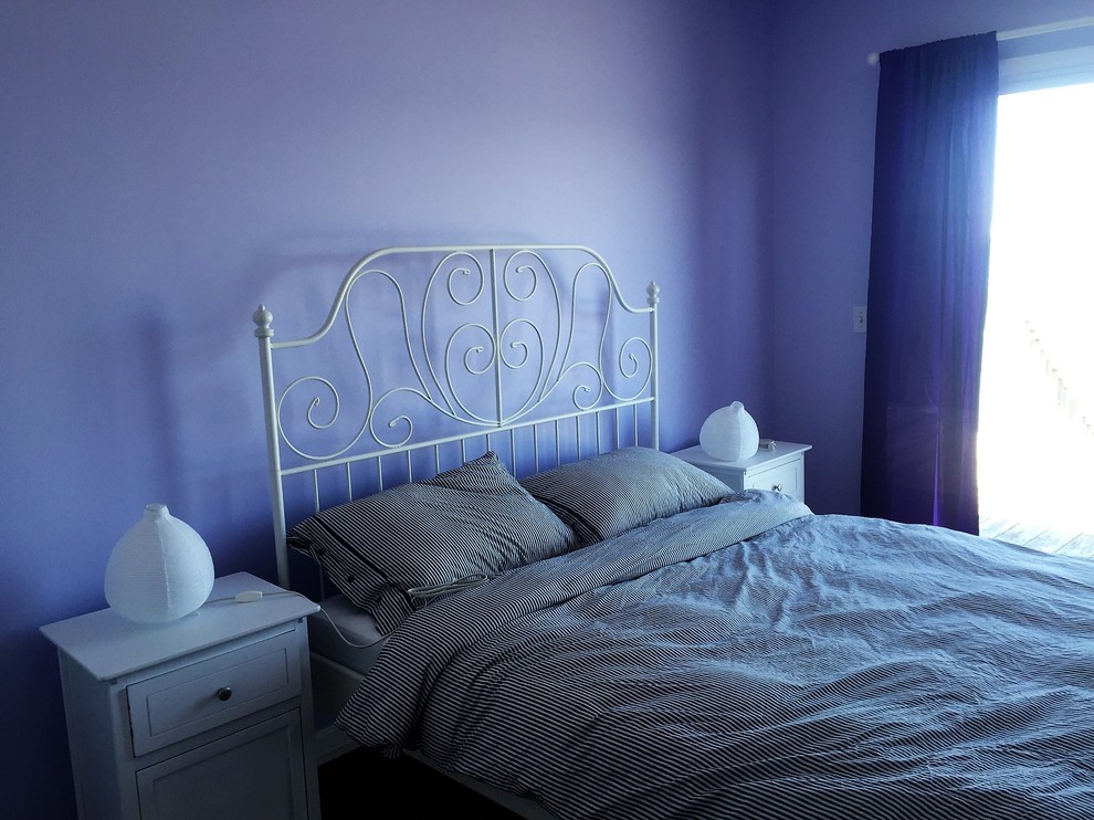 This is an example of a beach style guest bedroom in Atlanta with purple walls, vinyl floors and brown floor.