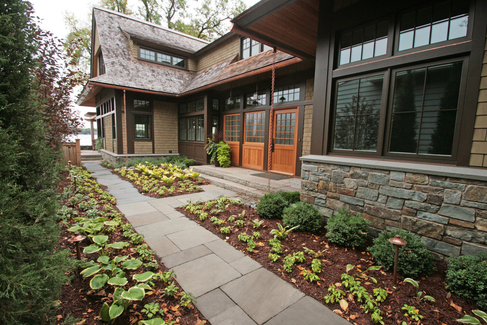 This is an example of an arts and crafts front yard partial sun garden in Minneapolis with natural stone pavers.
