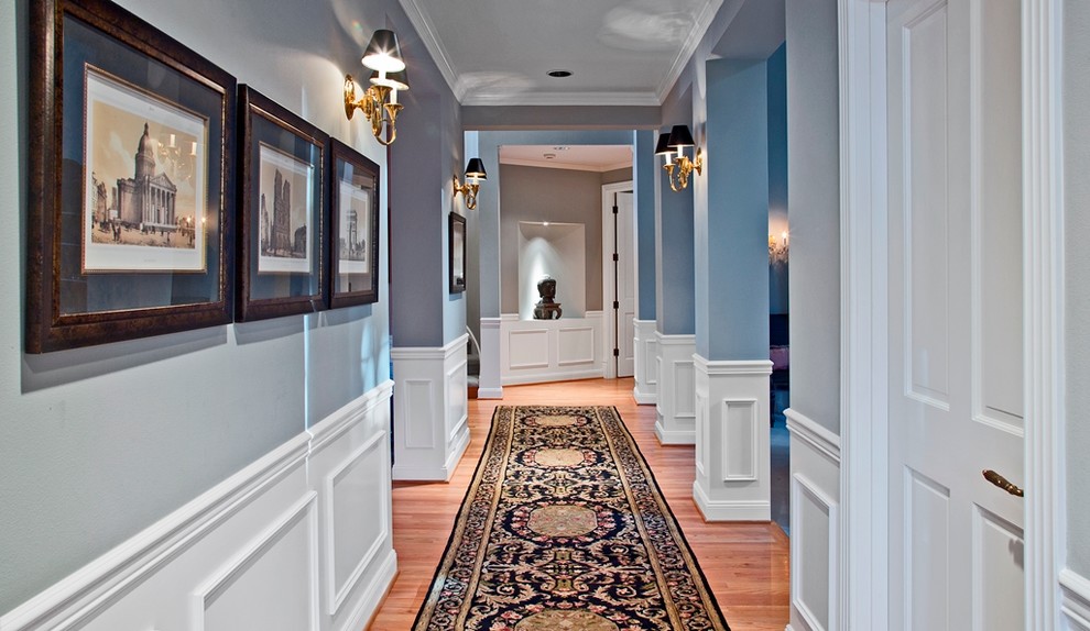Photo of a traditional hallway in Seattle with blue walls and light hardwood floors.