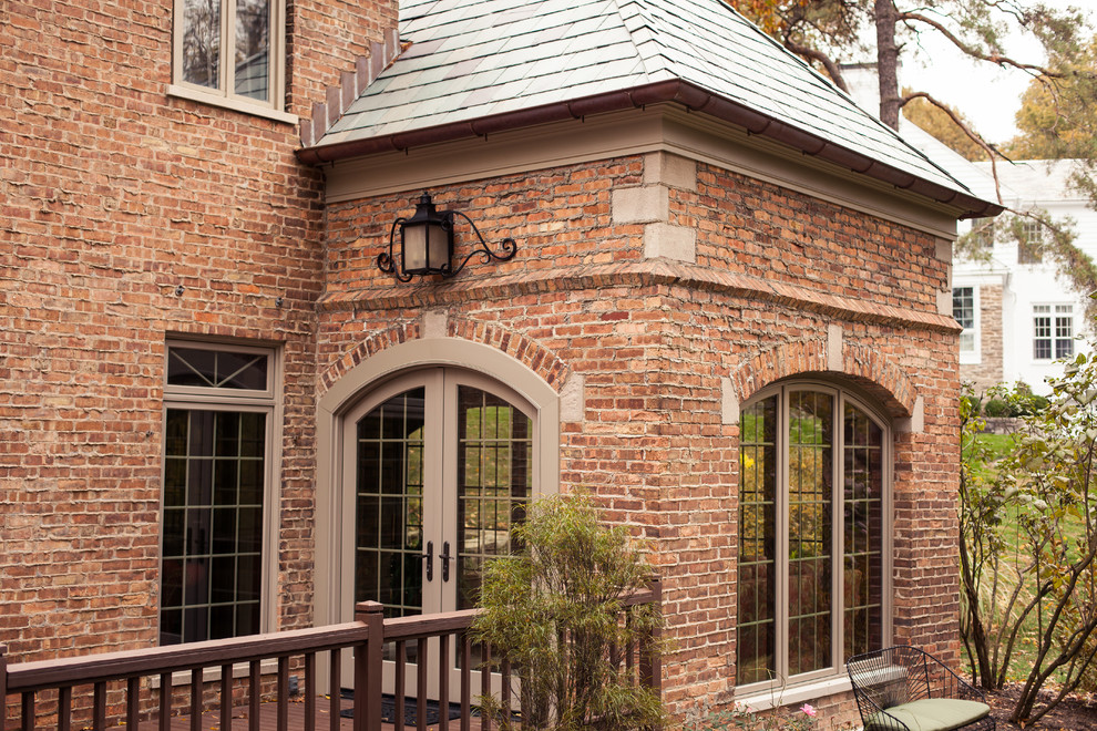 This is an example of a mid-sized transitional two-storey brick red exterior in Cincinnati with a gable roof.