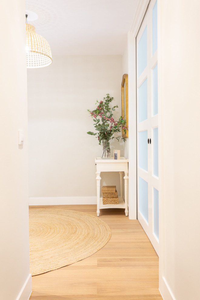 На фото: узкая прихожая среднего размера в стиле неоклассика (современная классика) с бежевыми стенами, полом из керамической плитки, раздвижной входной дверью и белой входной дверью
