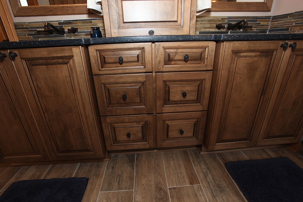 Freestanding bathtub - large rustic master slate tile brown floor freestanding bathtub idea in Indianapolis with brown cabinets, beige walls and an undermount sink