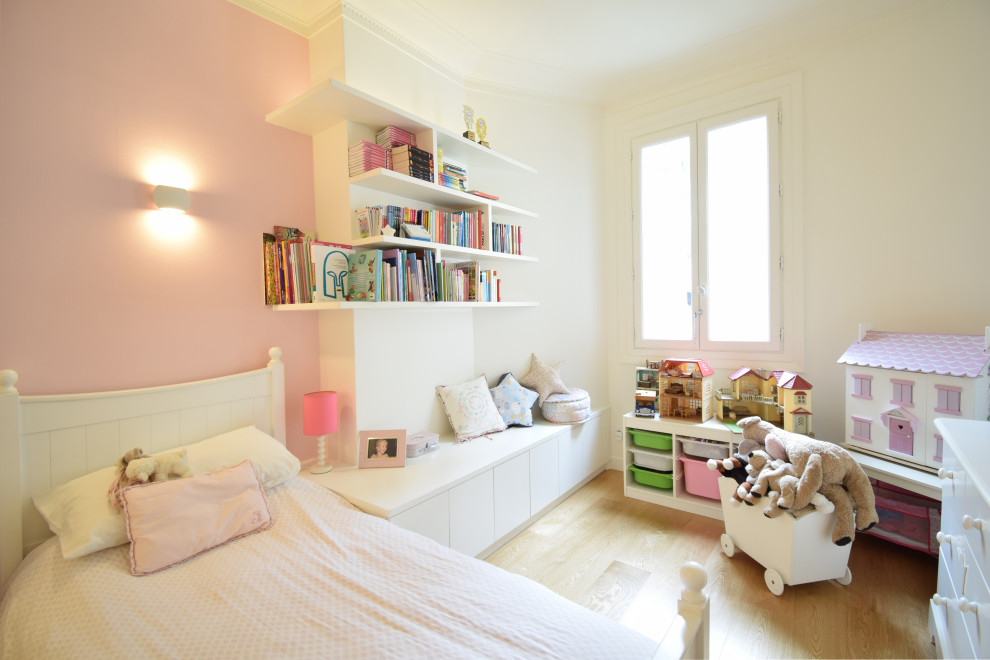 Mid-sized contemporary kids' bedroom in Paris with pink walls, light hardwood floors, beige floor and wallpaper for kids 4-10 years old and girls.