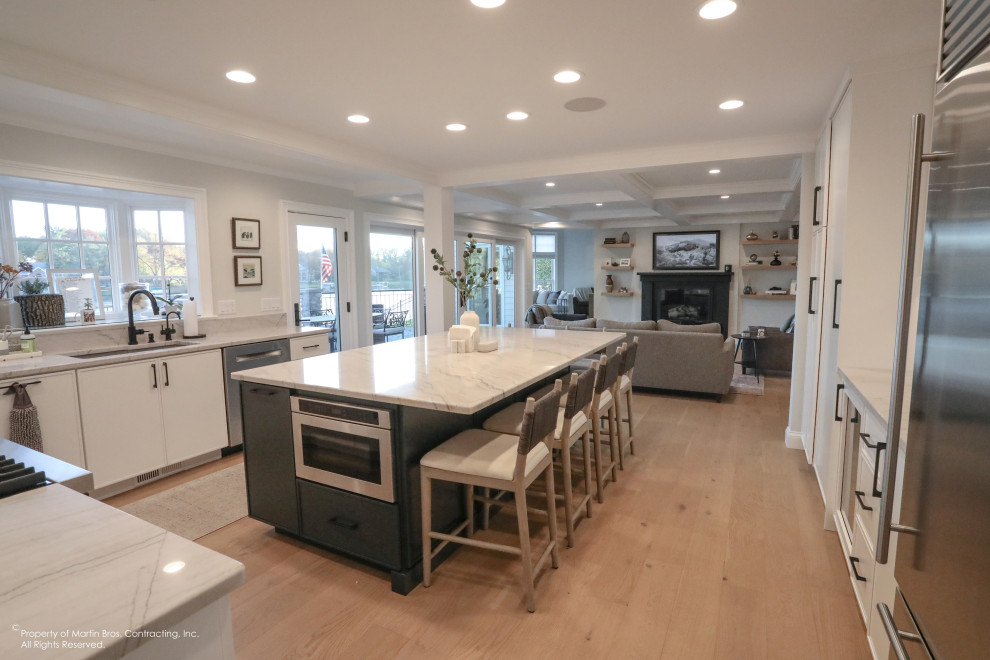 Inspiration for a large transitional u-shaped light wood floor open concept kitchen remodel with an undermount sink, flat-panel cabinets, white cabinets, quartzite countertops, white backsplash, porcelain backsplash, stainless steel appliances, an island and white countertops