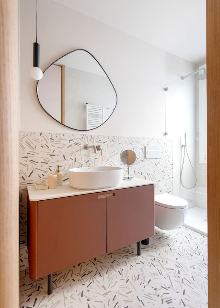 Photo of a mid-sized scandinavian master bathroom with furniture-like cabinets, white cabinets, a curbless shower, a wall-mount toilet, multi-coloured tile, multi-coloured walls, porcelain floors, a vessel sink, engineered quartz benchtops, multi-coloured floor, an open shower, white benchtops, a single vanity, a built-in vanity and wood walls.
