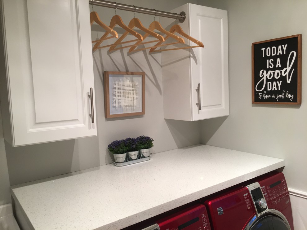 Small transitional galley laundry room in Toronto with a single-bowl sink, raised-panel cabinets, white cabinets, quartz benchtops, grey walls, travertine floors, a side-by-side washer and dryer and beige floor.