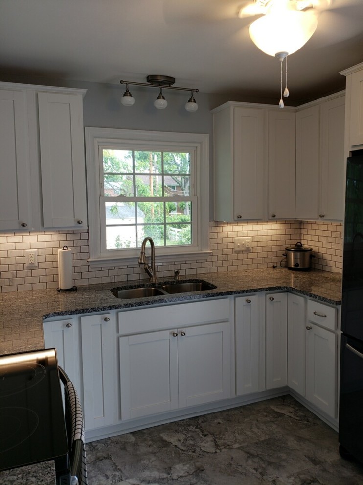 Inspiration for a small rustic u-shaped vinyl floor and gray floor enclosed kitchen remodel with an undermount sink, shaker cabinets, white cabinets, granite countertops, white backsplash, subway tile backsplash, black appliances, no island and multicolored countertops