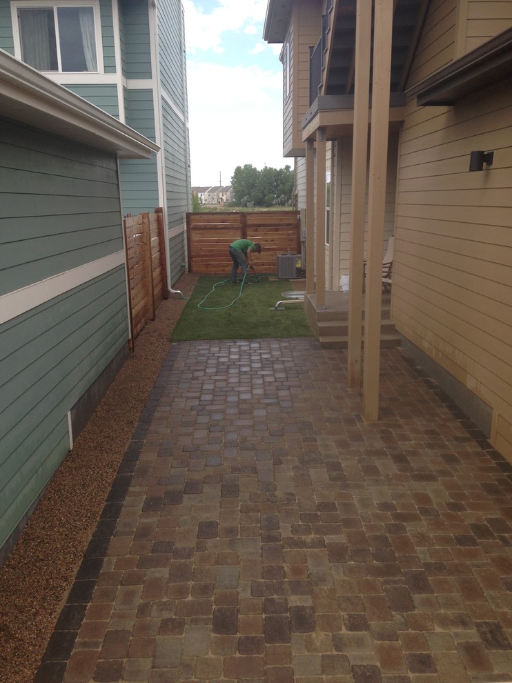 Inspiration for a small contemporary side yard patio in Denver with concrete pavers.