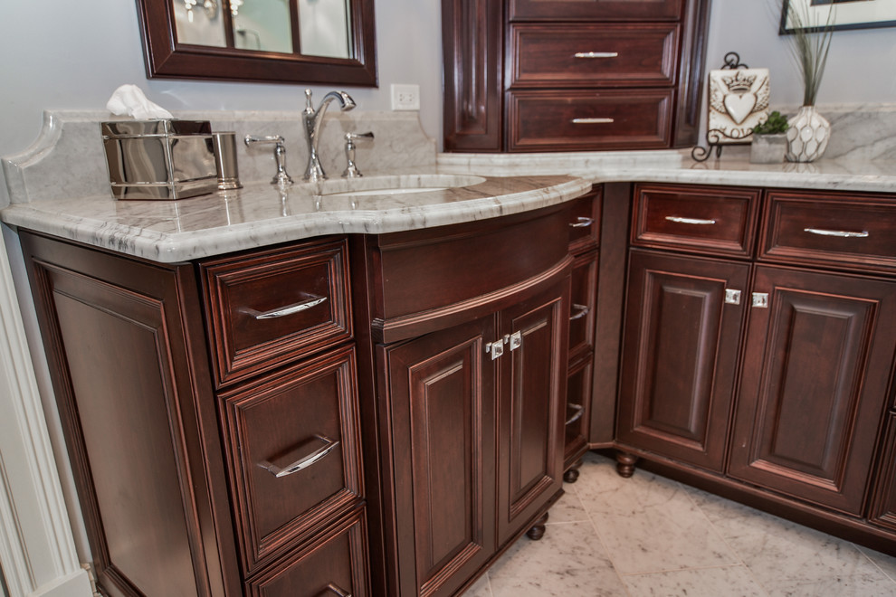 Photo of a large transitional master bathroom in Chicago with recessed-panel cabinets, dark wood cabinets, a freestanding tub, an alcove shower, gray tile, multi-coloured tile, white tile, glass tile, grey walls, marble floors, an undermount sink and marble benchtops.