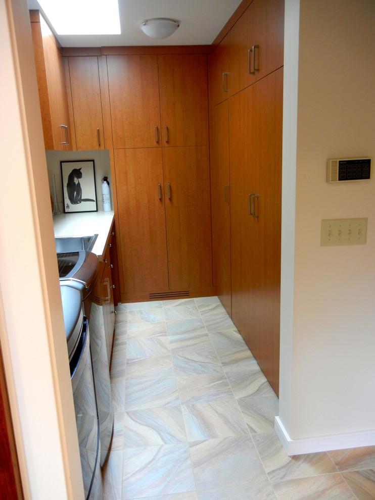 Design ideas for a mid-sized contemporary galley laundry cupboard in Minneapolis with flat-panel cabinets, medium wood cabinets, quartzite benchtops, beige walls, ceramic floors and a side-by-side washer and dryer.