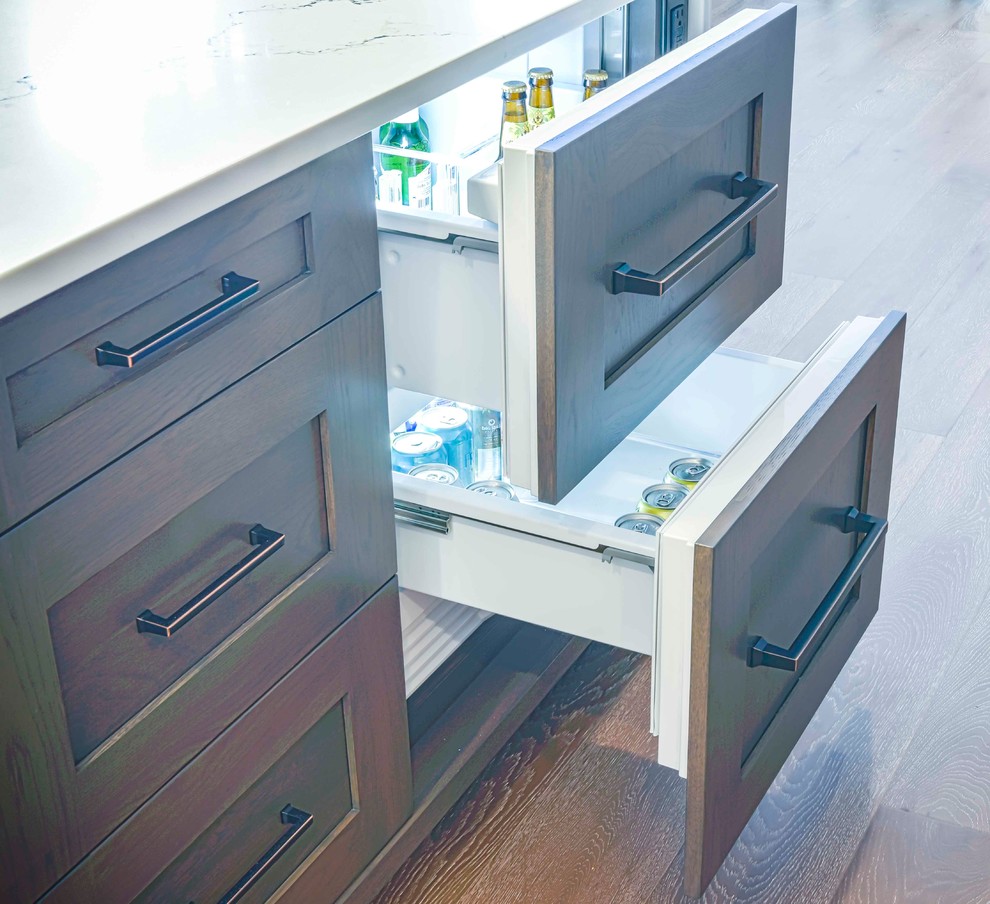 Inspiration for a mid-sized transitional u-shaped medium tone wood floor and brown floor home design remodel in Calgary with an undermount sink, flat-panel cabinets, white cabinets, marble countertops, gray backsplash, ceramic backsplash, paneled appliances and an island
