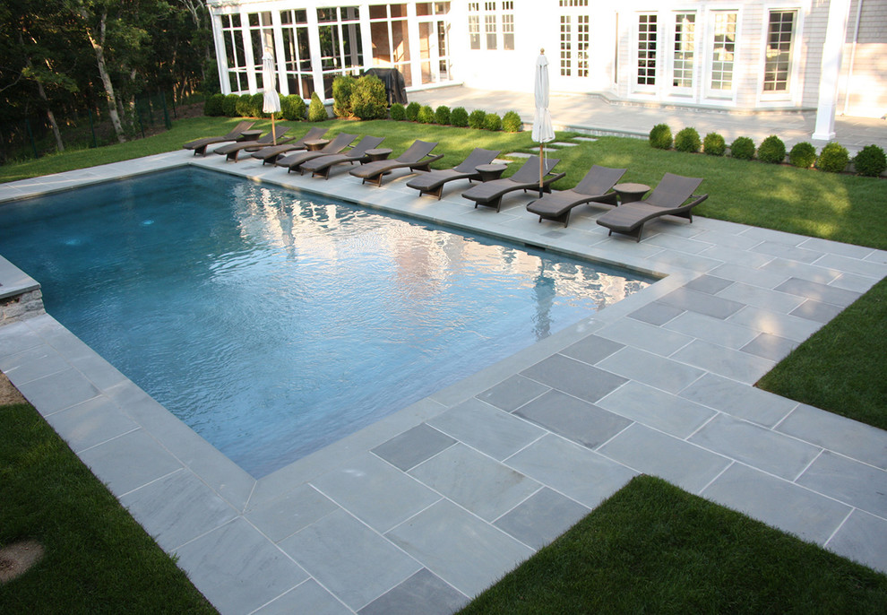 This is an example of a traditional backyard rectangular pool in New York with stamped concrete.