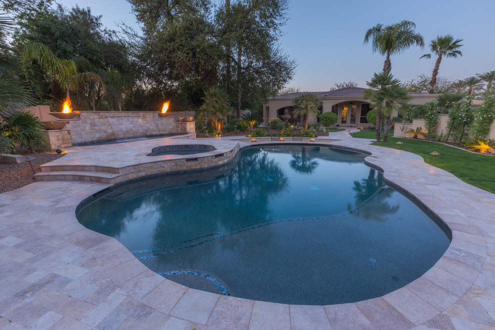 Photo of a large mediterranean backyard custom-shaped pool in Phoenix with a hot tub and tile.