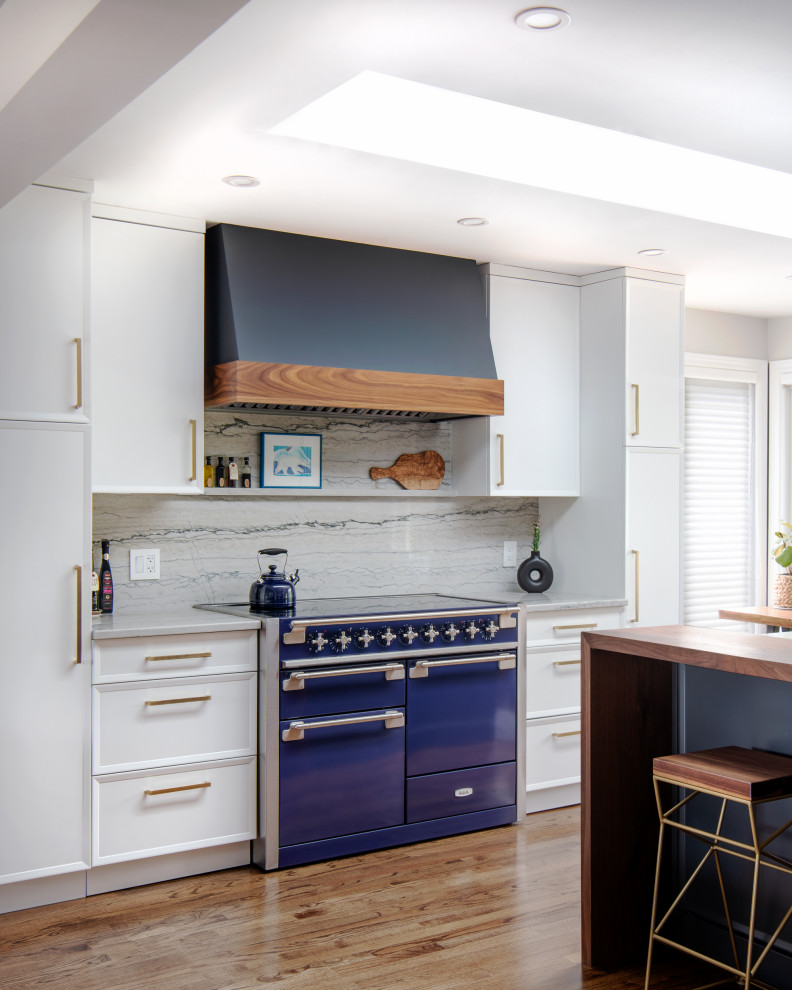 Idéer för stora vintage grått kök, med en undermonterad diskho, luckor med infälld panel, vita skåp, granitbänkskiva, grått stänkskydd, färgglada vitvaror, mellanmörkt trägolv, en köksö och brunt golv