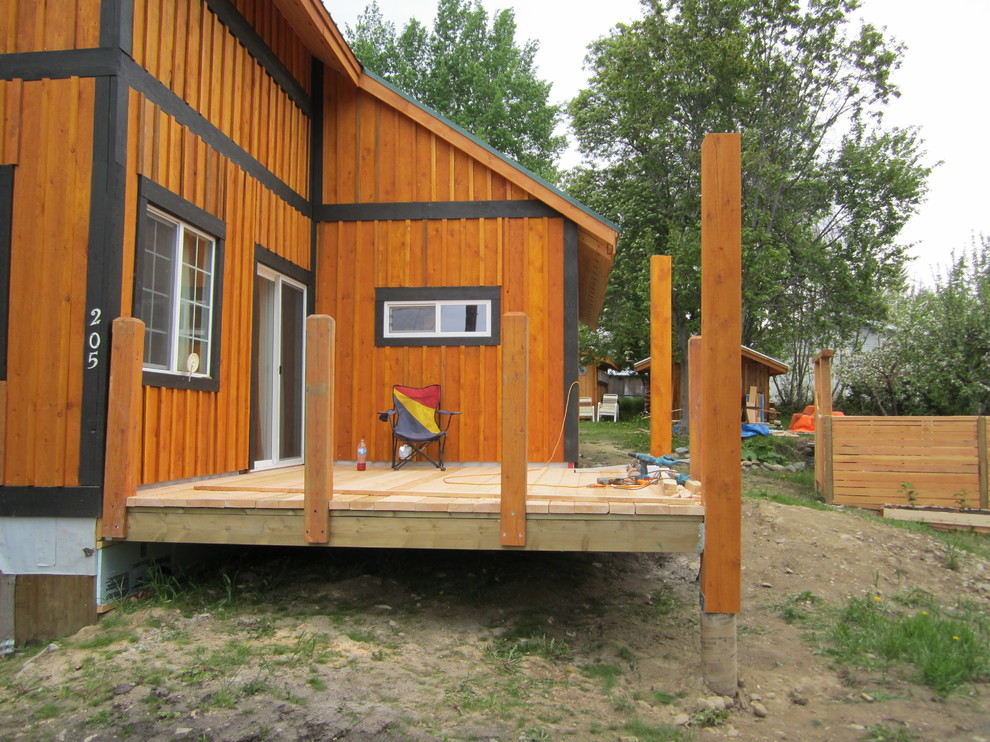Example of a mid-sized mountain style side yard balcony deck design in Vancouver with a roof extension