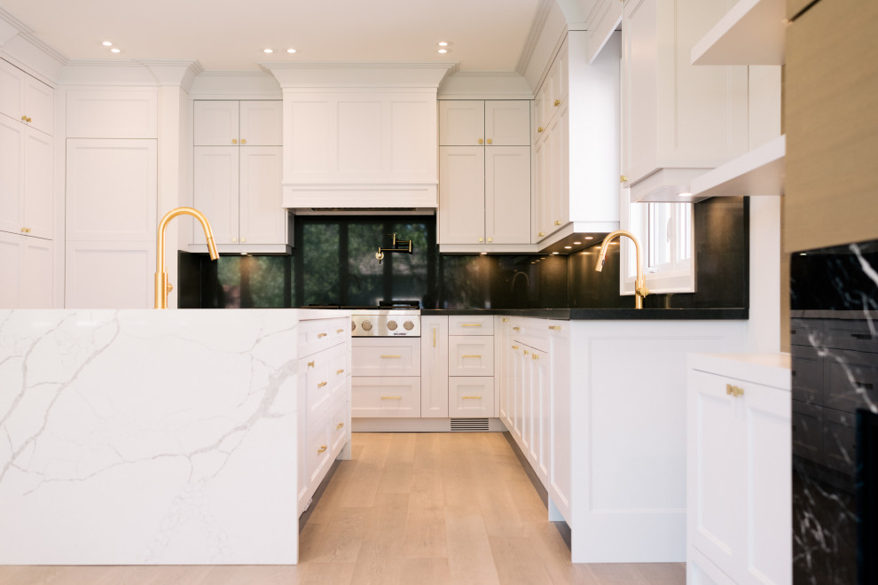 Example of a transitional u-shaped light wood floor and gray floor kitchen design in Toronto with an undermount sink, recessed-panel cabinets, quartz countertops, gray backsplash, quartz backsplash, paneled appliances, an island and white countertops