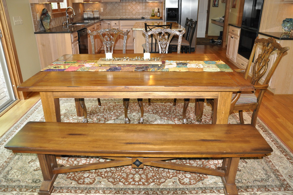 Eat-in kitchen - mid-sized transitional u-shaped medium tone wood floor eat-in kitchen idea in Cincinnati with an undermount sink, raised-panel cabinets, light wood cabinets, granite countertops, beige backsplash, porcelain backsplash, black appliances, green walls and an island