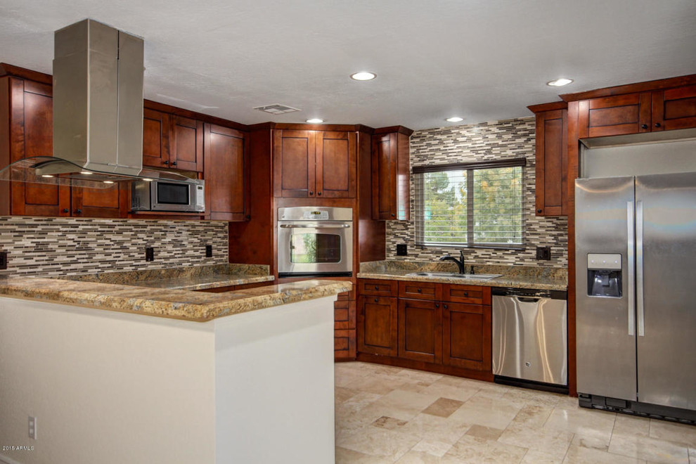 Inspiration for a large transitional u-shaped travertine floor and beige floor enclosed kitchen remodel in Phoenix with a drop-in sink, shaker cabinets, dark wood cabinets, granite countertops, multicolored backsplash, matchstick tile backsplash, stainless steel appliances, a peninsula and brown countertops