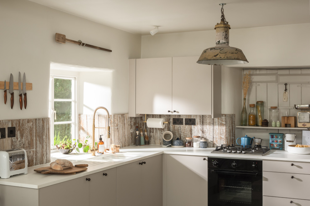 This is an example of a mid-sized country l-shaped kitchen in Other with a drop-in sink, flat-panel cabinets, white cabinets, quartzite benchtops, timber splashback, panelled appliances, slate floors, no island, grey floor and yellow benchtop.