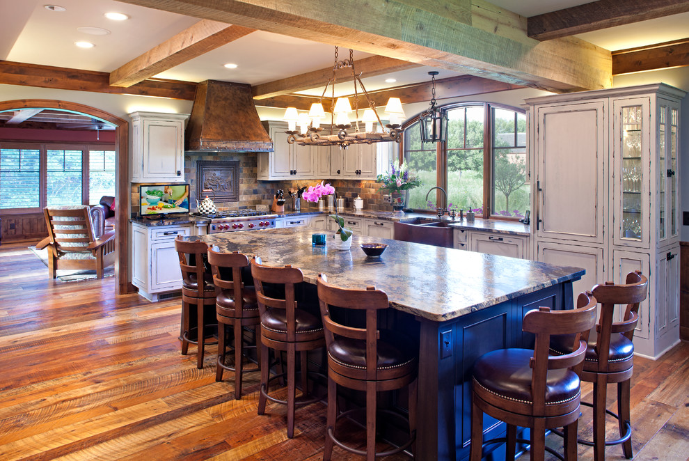 Large l-shaped eat-in kitchen in Minneapolis with a farmhouse sink, recessed-panel cabinets, distressed cabinets, medium hardwood floors, with island, granite benchtops, multi-coloured splashback and stainless steel appliances.