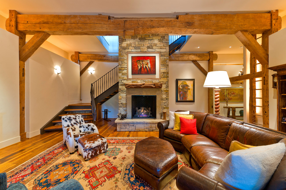 Design ideas for a traditional fully buried basement in Denver with a stone fireplace surround, a standard fireplace, medium hardwood floors, beige walls and orange floor.