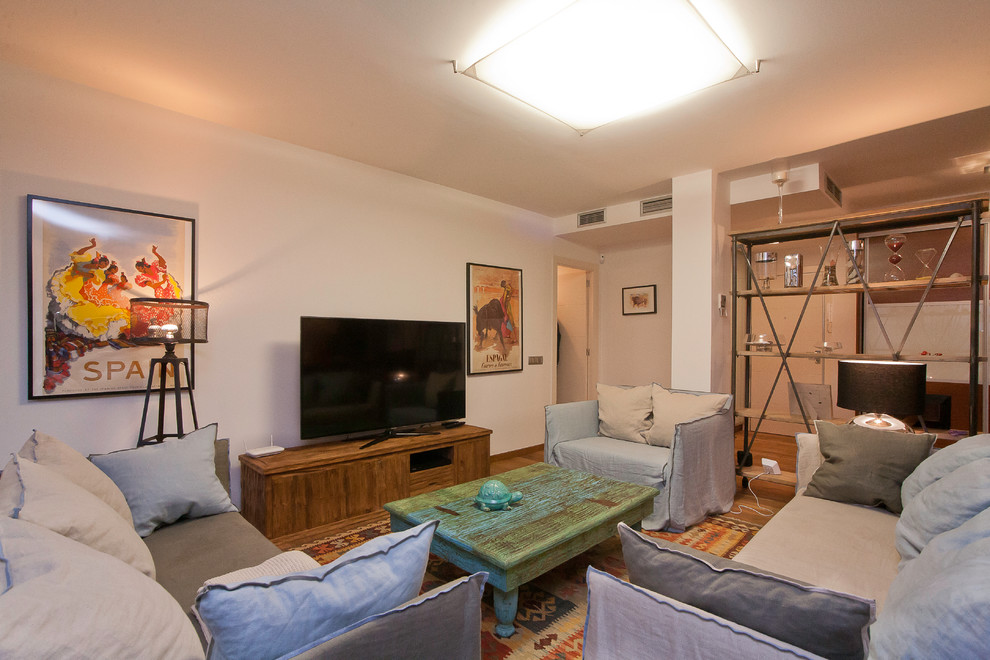 This is an example of a large contemporary formal open concept living room in Barcelona with white walls, medium hardwood floors, no fireplace and no tv.