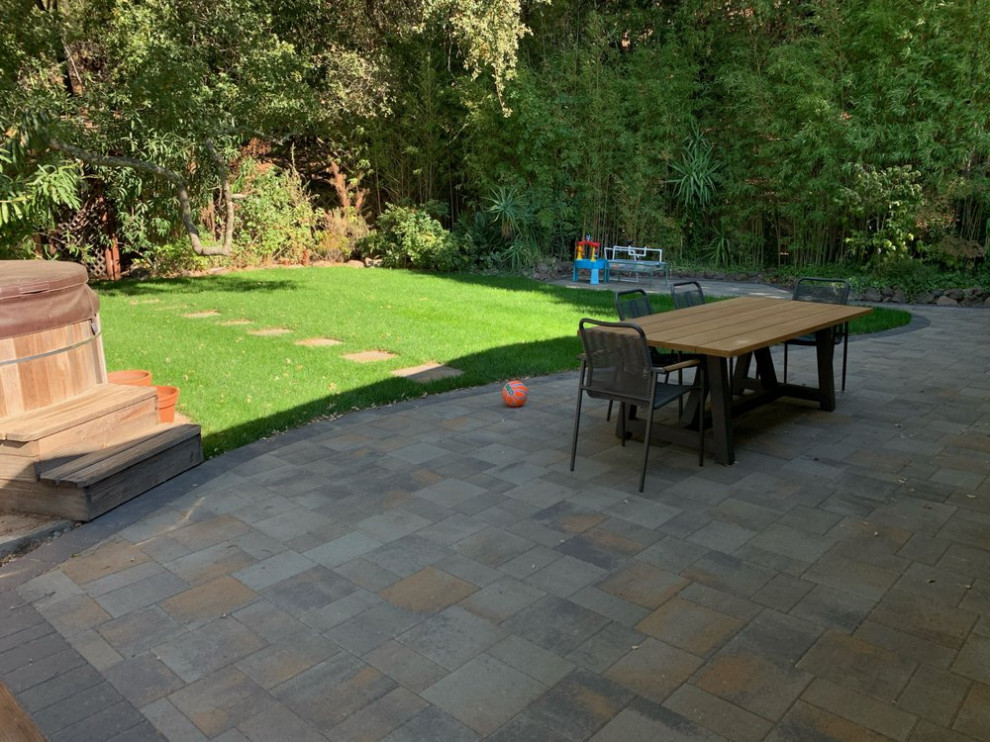 Imagen de jardín retro de tamaño medio en patio trasero con borde del césped, exposición parcial al sol y adoquines de piedra natural