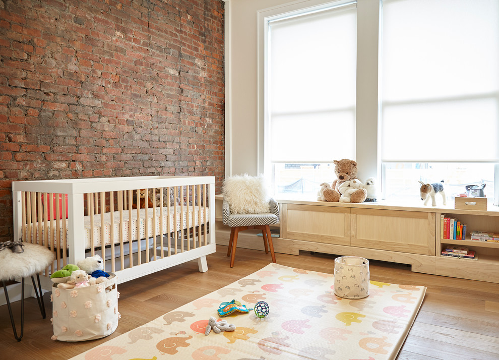 Design ideas for a mid-sized contemporary gender-neutral nursery in New York with light hardwood floors, red walls and beige floor.