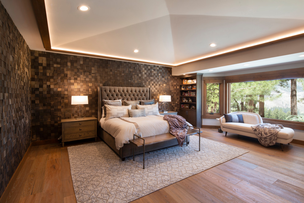 Großes Rustikales Hauptschlafzimmer mit grauer Wandfarbe, braunem Holzboden, Kamin, Kaminumrandung aus Metall, braunem Boden, gewölbter Decke und Holzwänden in Sonstige