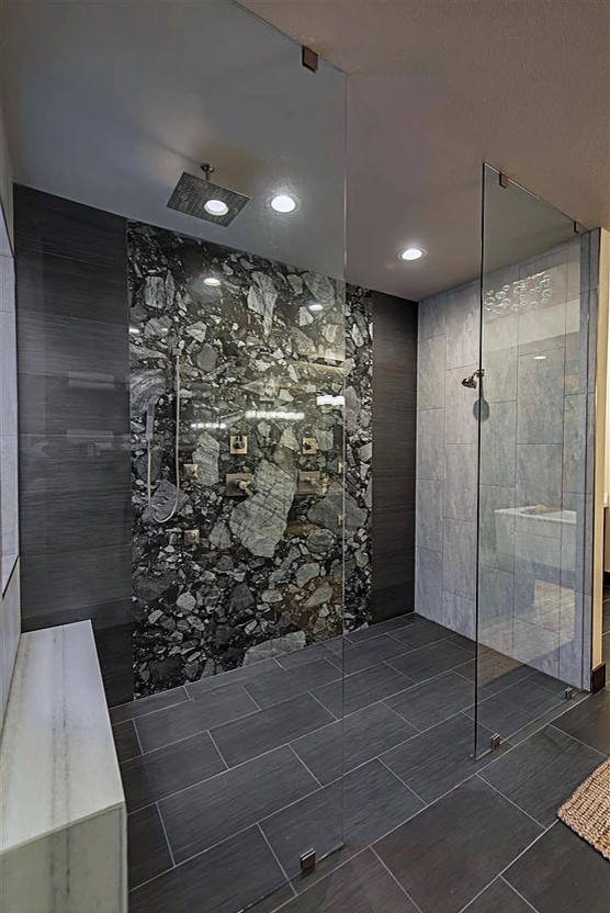 This is an example of a large asian master bathroom in Las Vegas with flat-panel cabinets, black cabinets, a freestanding tub, an open shower, a one-piece toilet, gray tile, grey walls, granite benchtops, an open shower, porcelain tile, porcelain floors, a vessel sink, black floor and white benchtops.