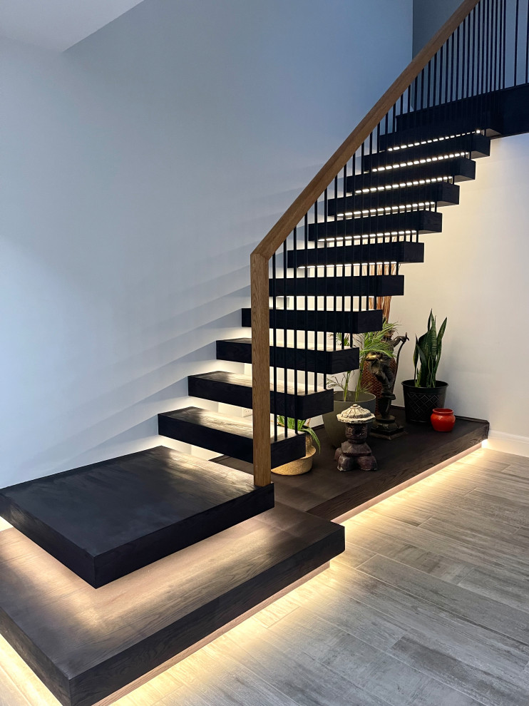 Design ideas for a large contemporary painted wood floating staircase in Berkshire with open risers and metal railing.