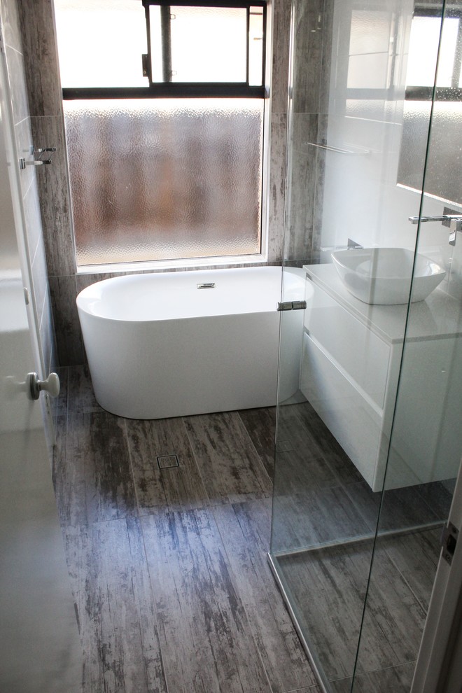 Inspiration for a large 3/4 bathroom in Perth with louvered cabinets, white cabinets, a freestanding tub, a corner shower, a one-piece toilet, white tile, porcelain tile, white walls, porcelain floors, a vessel sink, quartzite benchtops, multi-coloured floor and a hinged shower door.