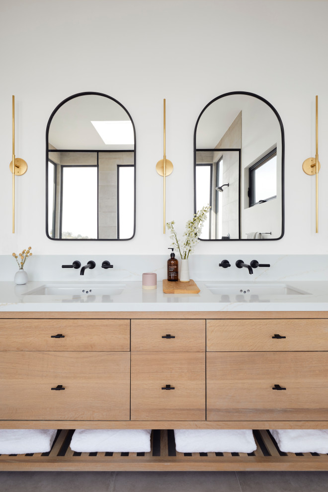 Пример оригинального дизайна: большая главная, серо-белая ванная комната в современном стиле с отдельно стоящей ванной, серой плиткой, белыми стенами, полом из керамогранита, врезной раковиной, столешницей из искусственного кварца, серым полом, белой столешницей, тумбой под две раковины, напольной тумбой, коричневыми фасадами, душевой комнатой, керамогранитной плиткой, душем с распашными дверями, окном и плоскими фасадами