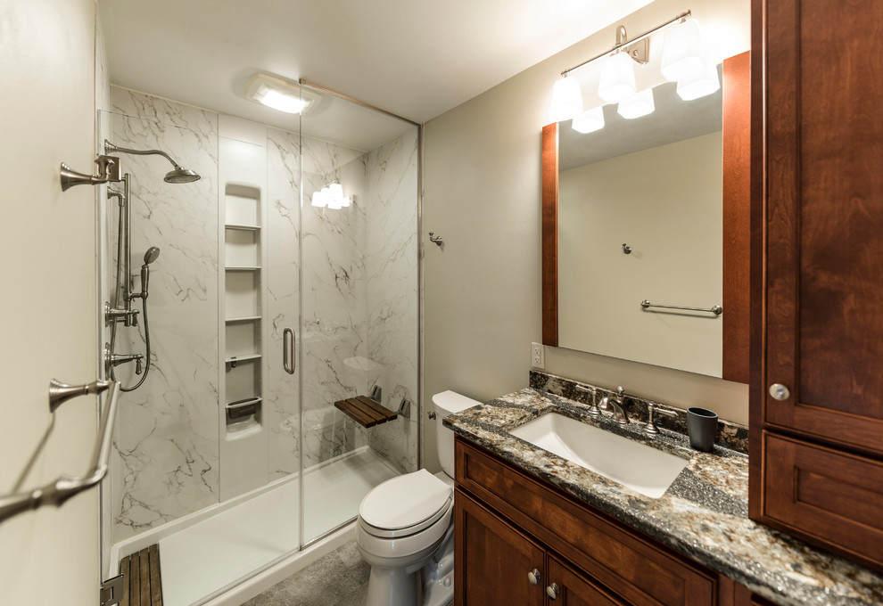 Mid-sized transitional bathroom in Other with recessed-panel cabinets, dark wood cabinets, an alcove shower, a two-piece toilet, white tile, marble, beige walls, cement tiles, an undermount sink, granite benchtops, grey floor, a hinged shower door and multi-coloured benchtops.